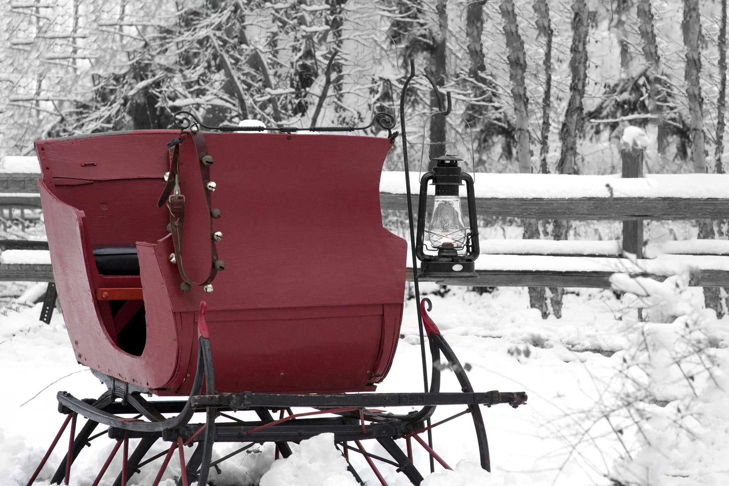 Red sleigh with a lantern on a snowy landscape